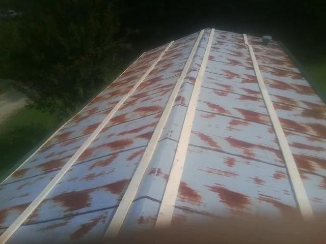 Rusted metal roof panels with new wood purlins before replacement — Storm Damage Roof Repair in Leicester by Roofing Brothers