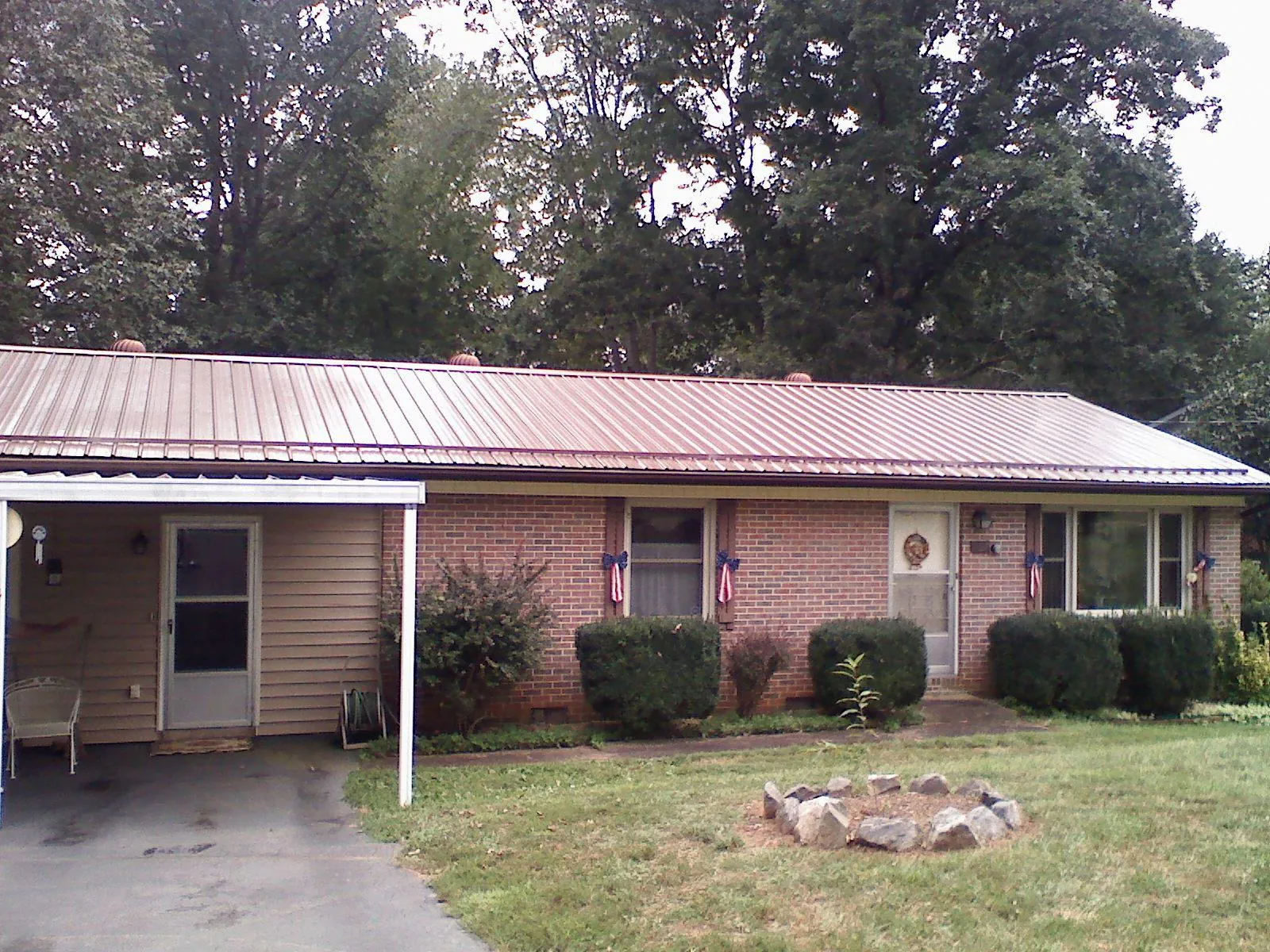 Bronze metal roof and carport on a brick ranch home — Roof Repair work by our crew in Leicester